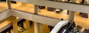 The atrium at UCL Marshgate, with furnished study floors above the escalators