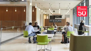 People working in a cafe furnished by JPA Workspaces, with the JPA Workspaces 50 years badge